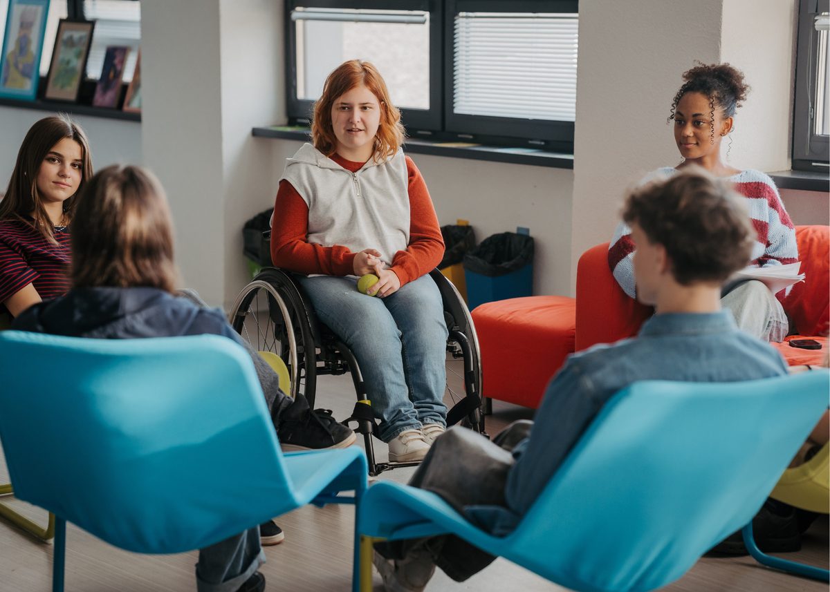 A group of teenagers seated in a circle during a peer support session